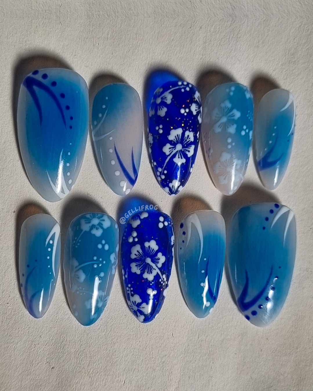 Beach Cocktails medium almond press-on nails by Gellifrog – pale blue aura design with hibiscus accent